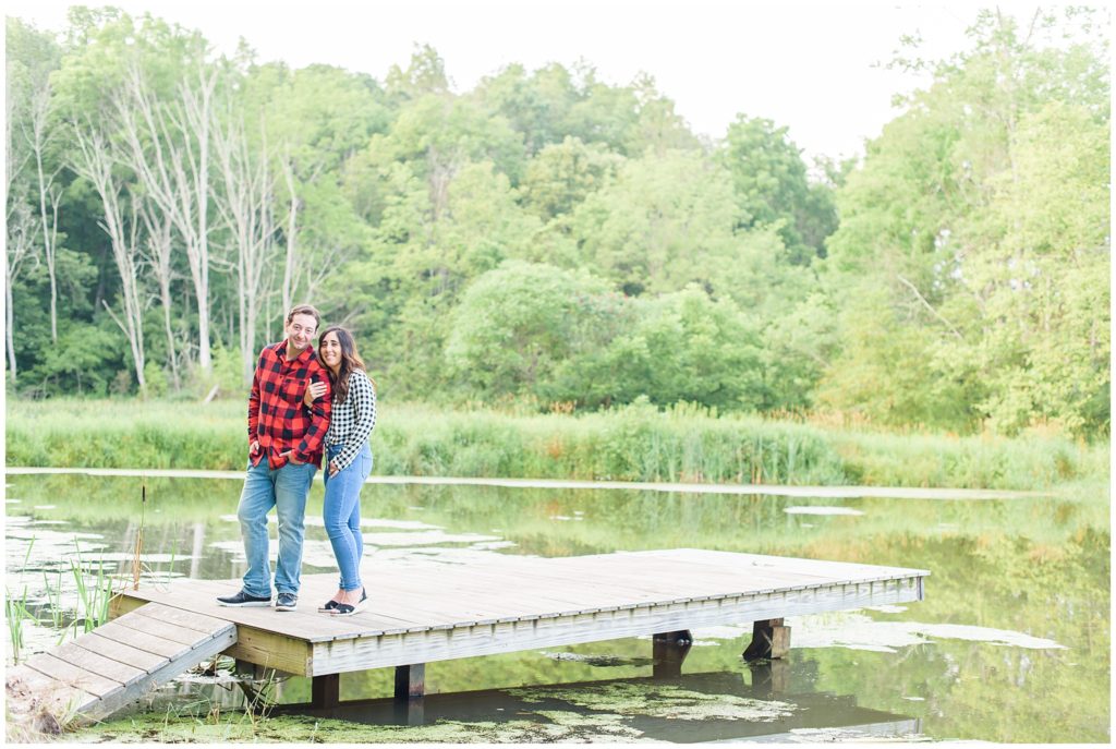 couple standing on dock by lake
