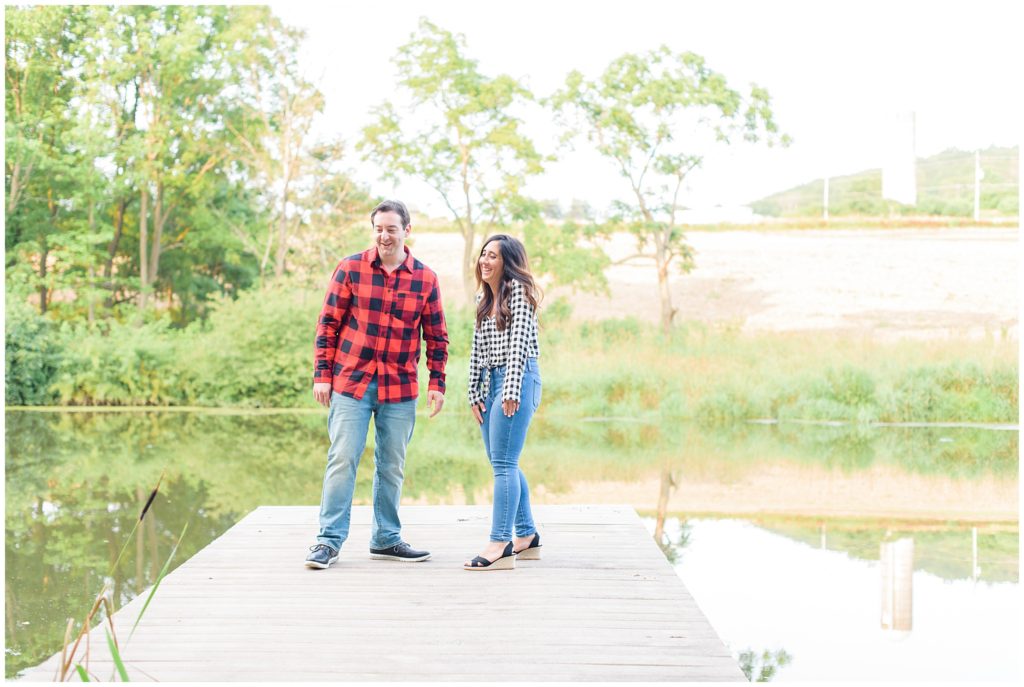 couple standing on dock by lake