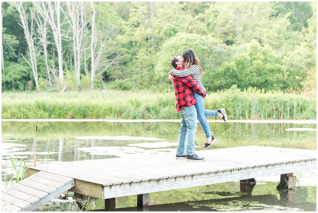 couple kissing on dock by lake