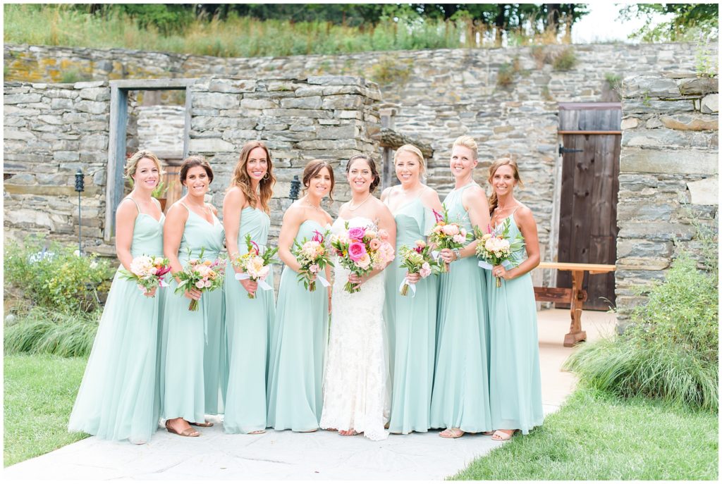 bridal party in front of stone wall