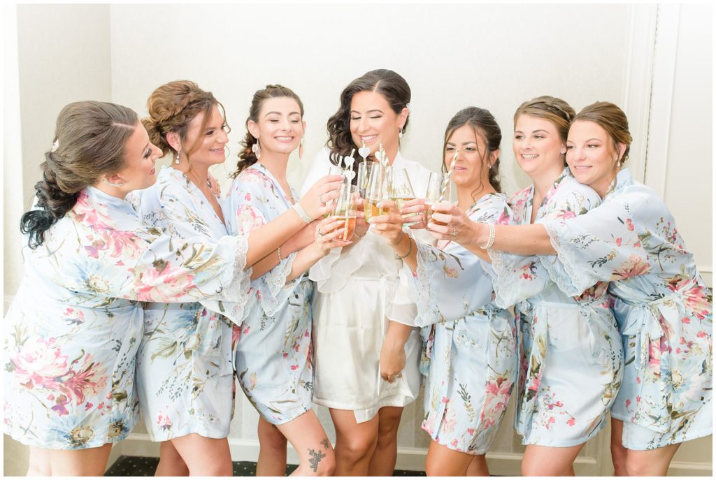 bridesmaids popping champagne in floral robes