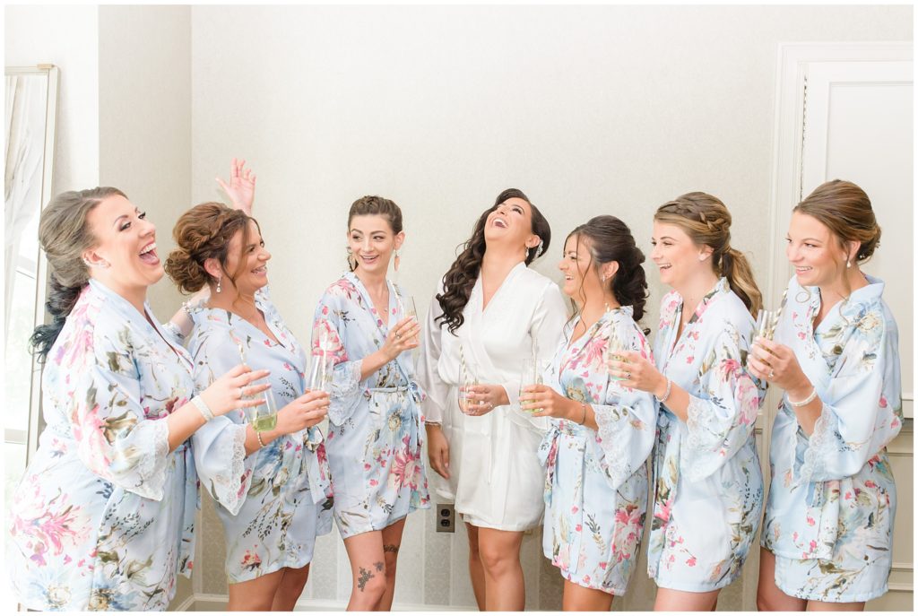 bridesmaids popping champagne in floral robes